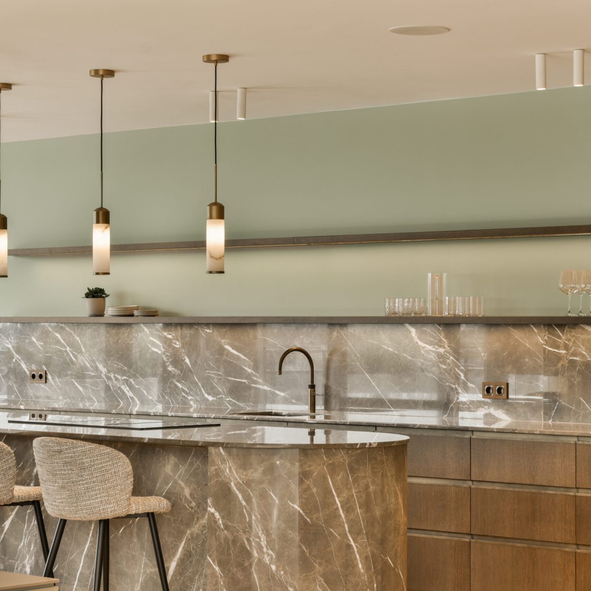 a modern kitchen with marble counter tops and bar stools in the photo is taken from the doorway to the dining area