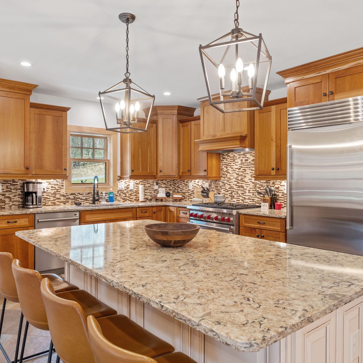 A modern kitchen with a granite island countertop and wooden cabinetry.